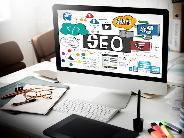 Desktop computer showing SEO strategy sketch with content, sharing and website design elements
