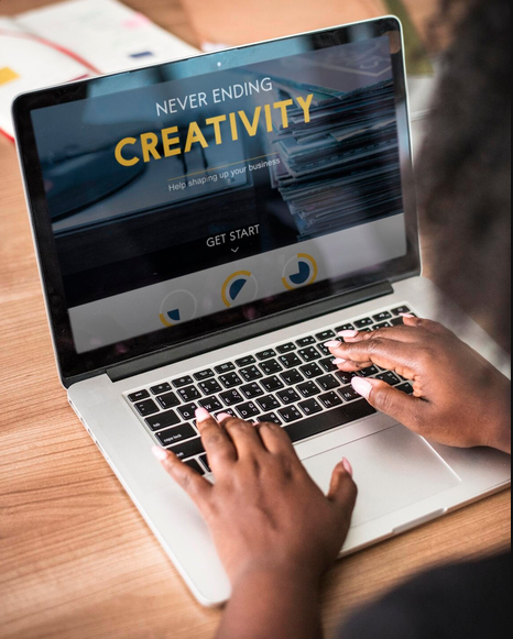 Designer working on desktop computer with web design wireframe, HTML code note and website elements